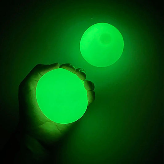 Two green glowing balls being held against a dark background